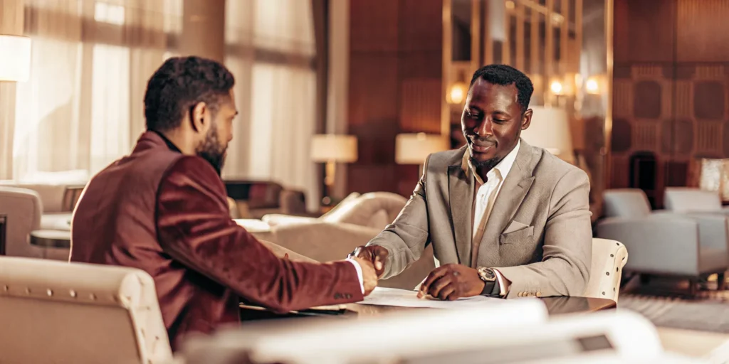 Real estate investor reviewing documents with a qualified intermediary in a professional office setting, trust and professionalism atmosphere